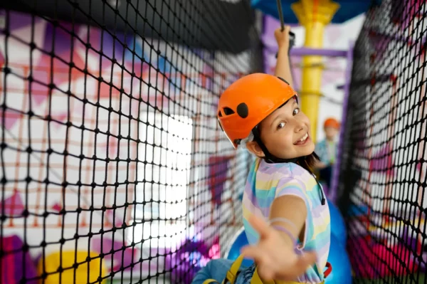 Little girl climbs on the ropes, zip line